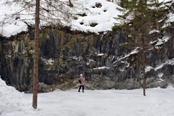 Woman stands near a steep cliff