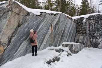 A woman takes a photo near a cliff